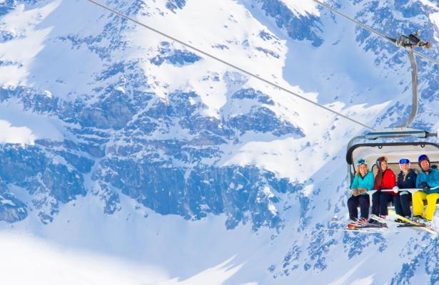 A group of people riding a ski lift in the mountains is a simple and hospitable charm.